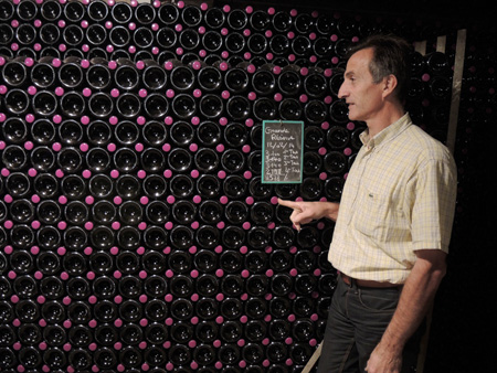 Patrick Manceaux in the cellar in front of the bottles of Cuvée Grande Réserve in stacks.